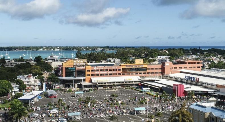 An aerial shot taken in April 2020 shows people waiting while adhering to social distancing in a parking lot before entering a supermarket in Grand Baie, Mauritius; the country has declared wary victory over the coronavirus