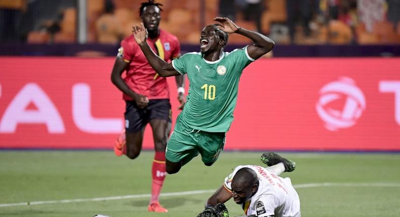 Uganda goalkeeper Denis Onyango fouls Senegal forward Sadio Mane, whose penalty kick was saved in an Africa Cup of Nations last-16 match in Cairo