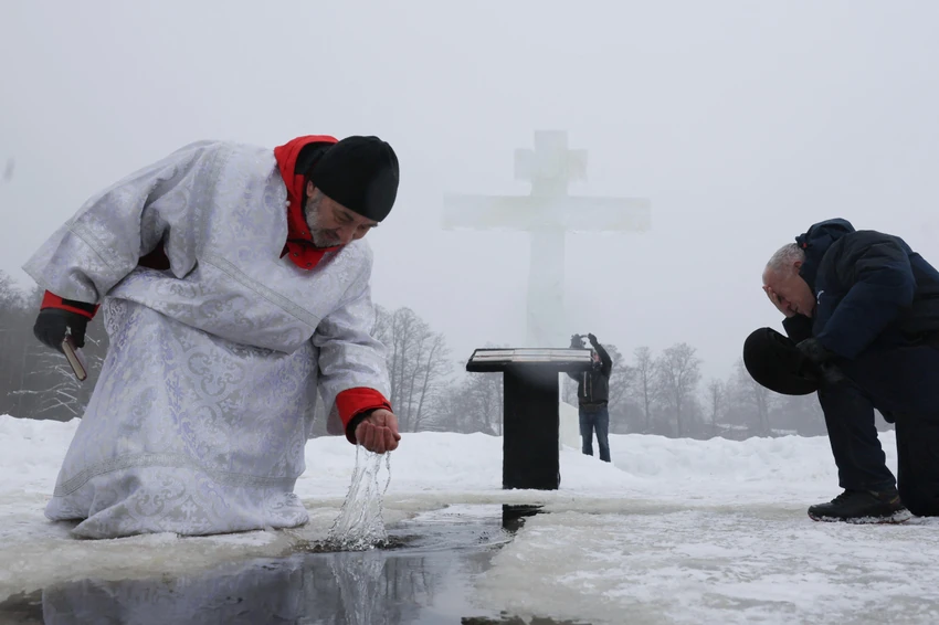 Sveštenik zahvata vodu tokom proslave pravoslavnog hrišćanskog praznika Bogojavljanja u blizini sela Gora-Valdaj, izvan Sankt Peterburga u Lenjingradskoj oblasti, Rusija, januar 2026. | Foto: REUTERS/Anton Vaganov