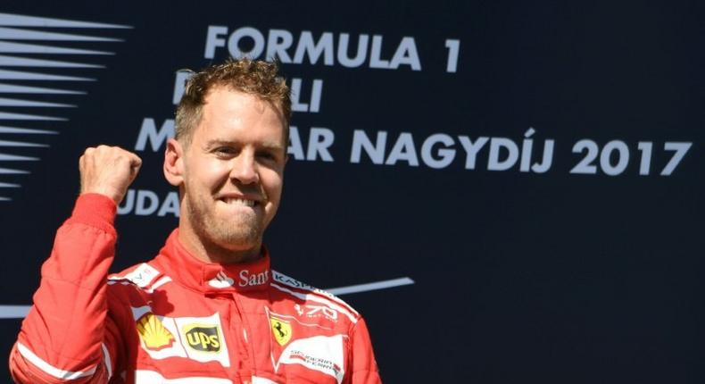 Ferrari's German driver Sebastian Vettel celebrates at the Hungaroring racing circuit in Budapest on July 30, 2017, after winning the Formula One Hungarian Grand Prix
