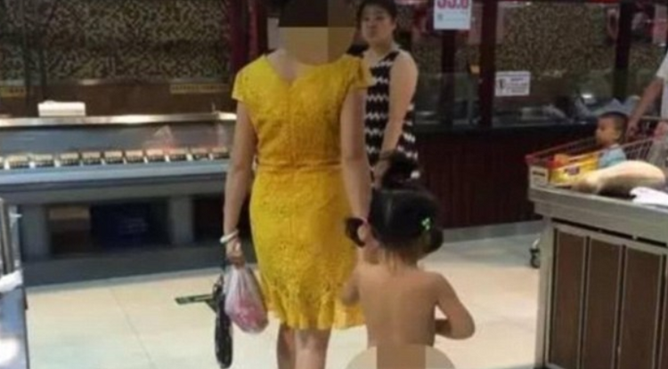 A kínai édesanya és meztelen kislánya vásárolnak.