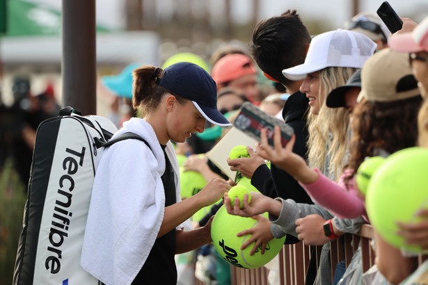 Iga Świątek (L) rozdaje autografy podczas treningu przed tenisowym turniejem WTA w Indian Wells