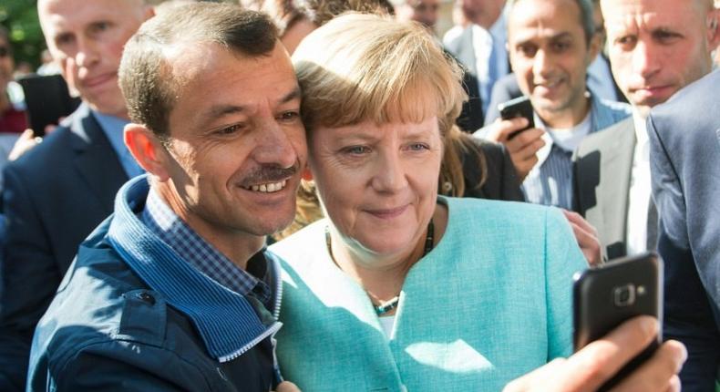 An asylum seeker takes a selfie with Angela Merkel in Berlin