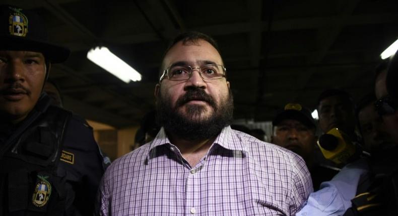Javier Duarte, former governor of the Mexican state of Veracruz, accused of graft and involvement in organized crime, is escorted by police officers for a hearing to decide on his extradition, at the Supreme Court in Guatemala City on June 27, 2017