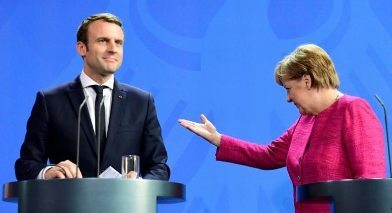 German Chancellor Angela Merkel gestures to French President Emmanuel Macron after addressing a press conference at the chancellery in Berlin on May 15, 2017