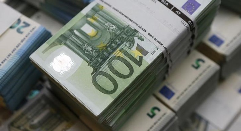 Wads of euro banknotes are stacked in a pile at the Money Service Austria company's headquarters in Vienna, Austria, March 3, 2016. 