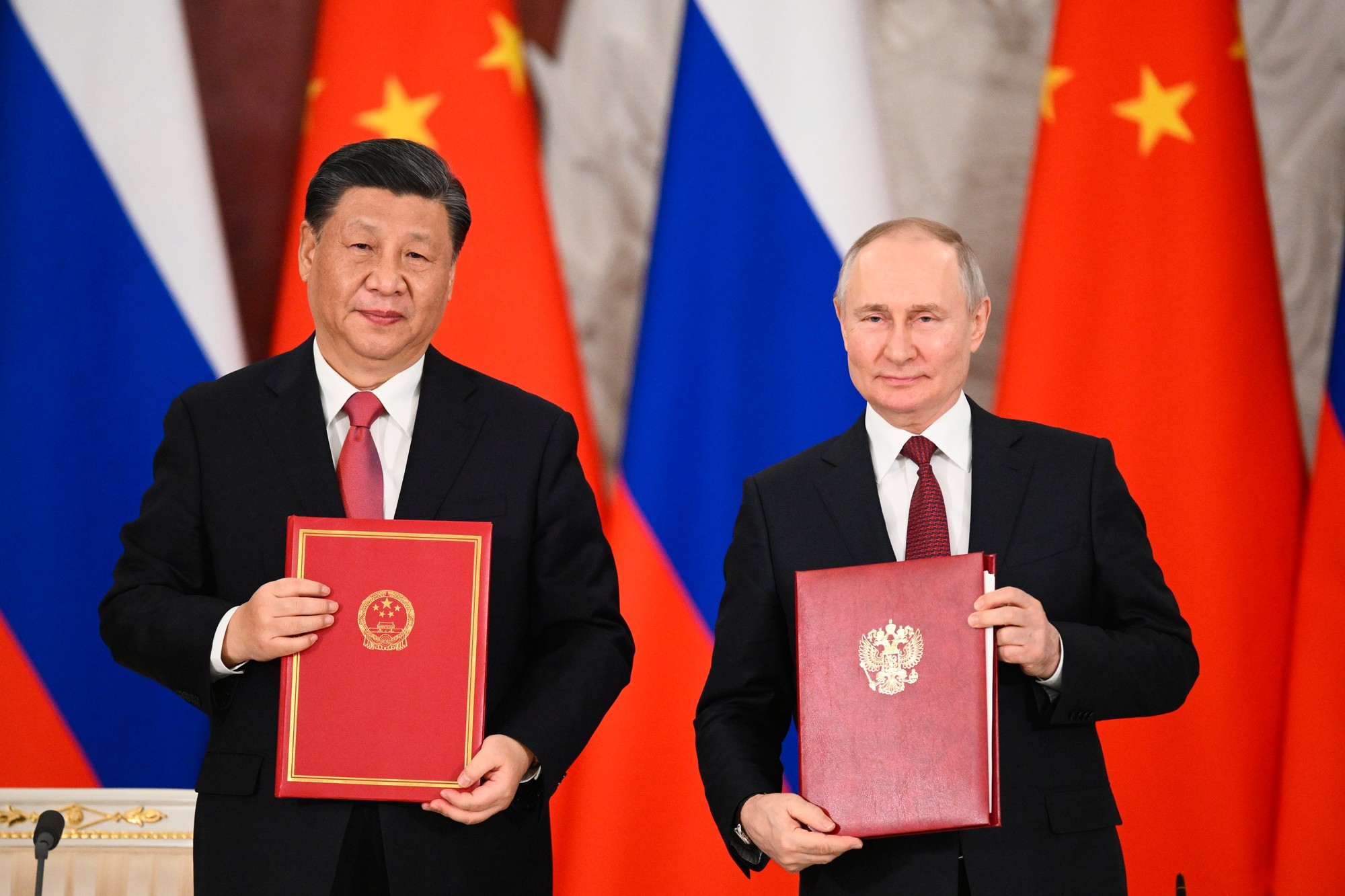 Ruský prezident Vladimir Putin (vpravo) a čínsky prezident Si Ťin-pching pózujú po podpísaní dokumentov o strategickej spolupráci 21. marca 2023 v Moskve.