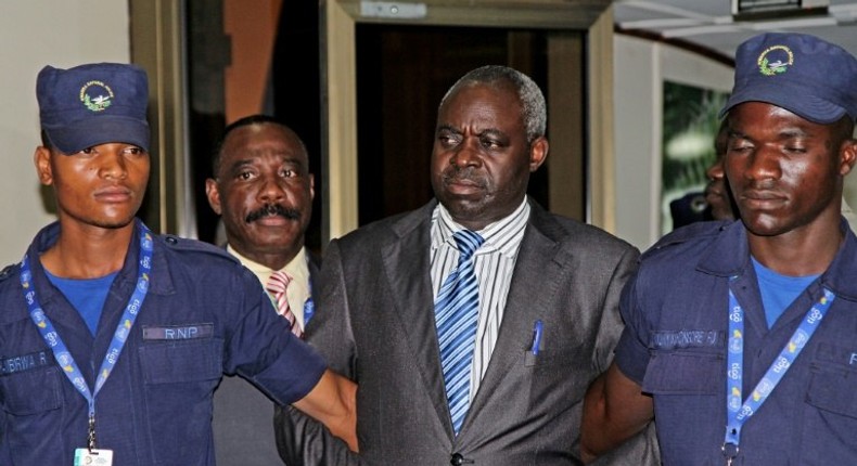 Former Hutu militia leader Bernard Munyagishari (C) is escorted by police upon his arrival at Kigali airport on July 24, 2013