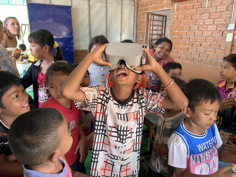 Uczniowie ze szkoły ASEAN bawiący się okularami VR przywiezionymi przez wolontariuszy
