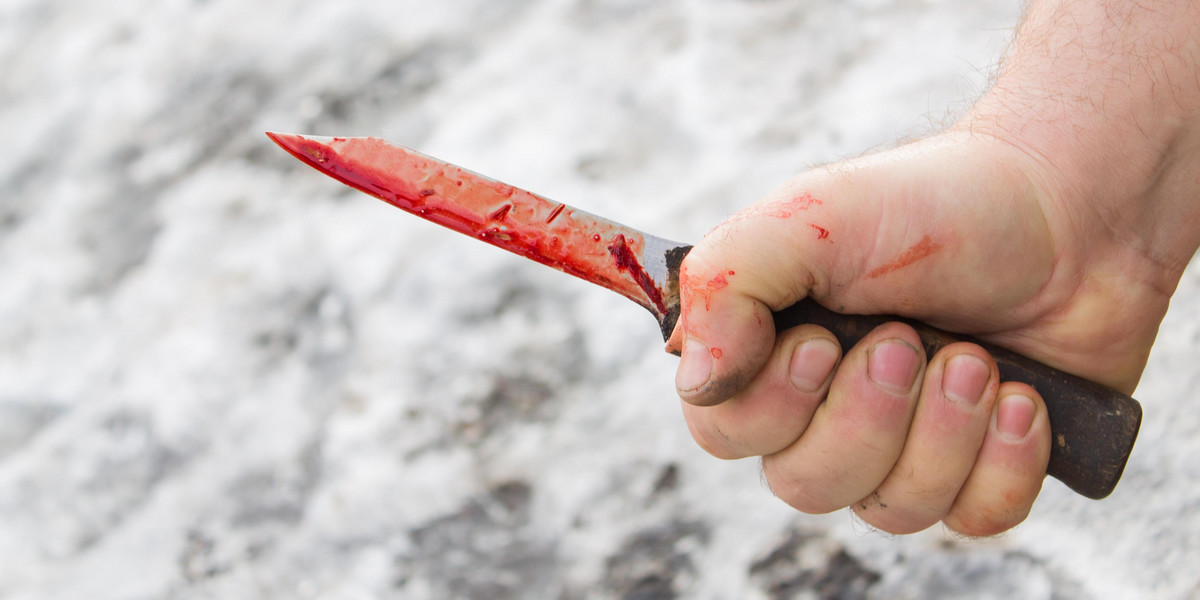 man's hand with a bloody knife