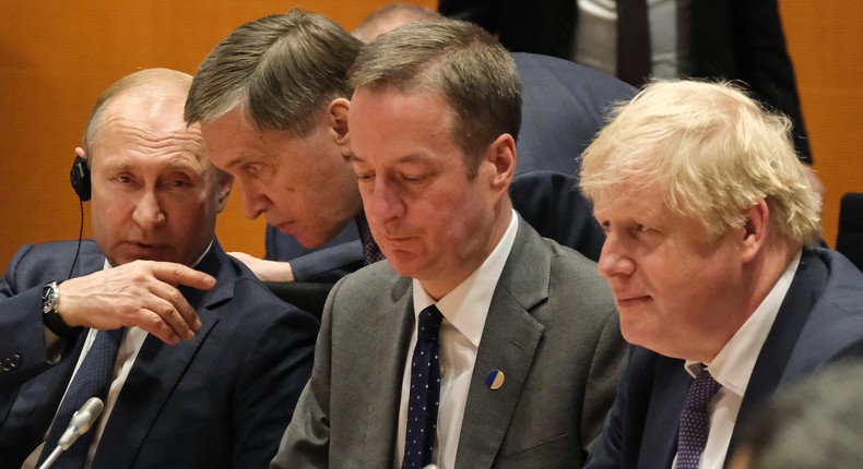 Russian President Vladimir Putin (L), and British Prime Minister Boris Johnson (R) attend the main session at an international summit on securing peace in Libya at the Chancellery on January 19, 2020 in Berlin, Germany.