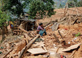 Woman sits on the rubble of her house at village following Saturday's earthquake in Sindhupalchowk