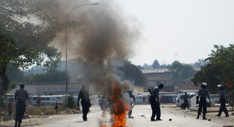 Demonstrators from the Zimbabwean pressure group Tajamuka protest next to a burning tyre in Makokoba Township, Bulawayo