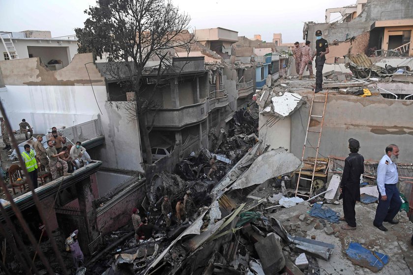 Rescue workers gather at the site of a passenger plane crash in a residential area near an airport i