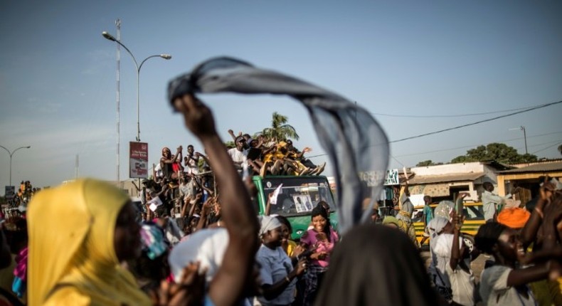 Supporters of Adama Barrow, flag-bearer of the coalition of the seven opposition political parties in Gambia, gather in the streets of Talinding on the outskirts of Banjul on November 25, 2016 to try to catch a glimpse of the candidate's motorcade