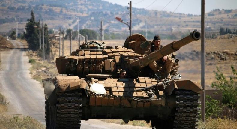 Opposition fighters drive a tank in Syria's southwestern Quneitra province in June 2017