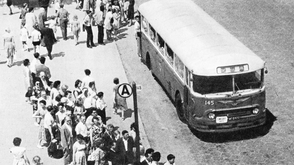 Zatłoczony przystanek autobusowy w stolicy, lata 60. (domena publiczna).