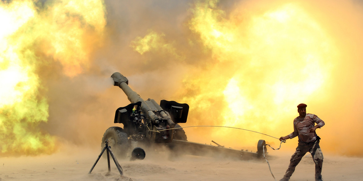 A member of the Iraqi security forces fires artillery during clashes with ISIS militants near Fallujah, Iraq.