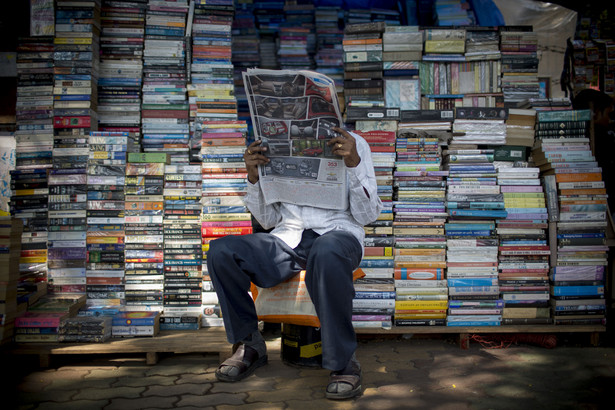 Sprzedawca czyta gazetę w Mumbaju