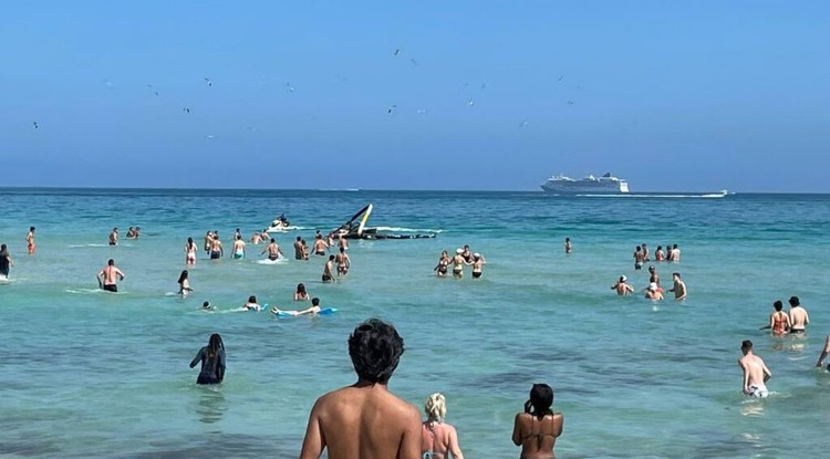 Strandolók figyelik a pillanatokkal korábban lezuhant gépet a Miami Beachen