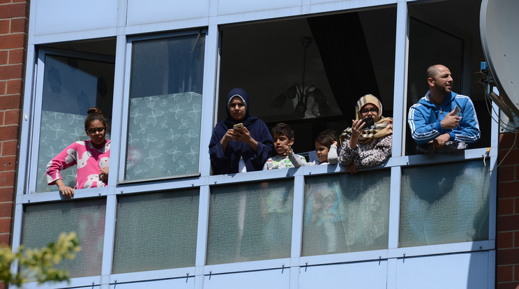 Menekültek egy berlini ház ablakában /Fotó: AFP