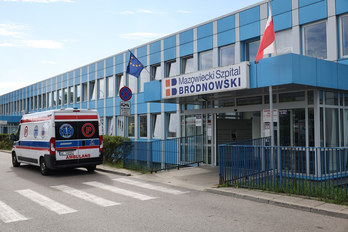Szpital Bródnowski w Warszawie. Widać wejście, przed nim na poboczu zaparkowana karetka