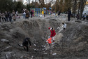 Dzieci bawią się w kraterach po pociskach w Kijowie, 16 października 2022 r.