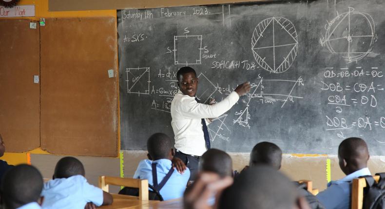 A head teacher at Mbazzi Primary School during a class session. Government has been asked to raise teachers' salaries fairly and without discrimination
