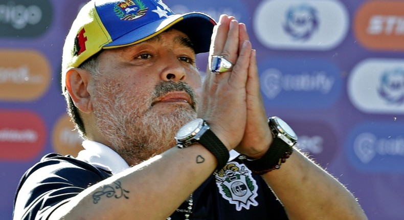 Maradona gestures to supporters as he leaves the field after a Superliga match against Estudiantes