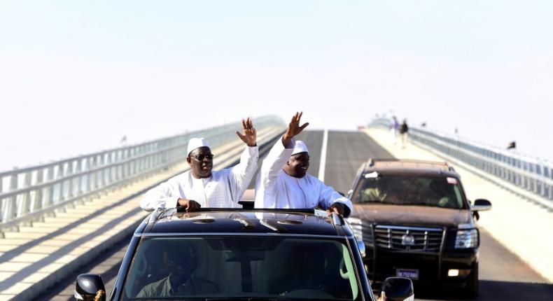 Senegal's president Macky Sall (L) and Gambian President Adama Barrow (R) wave as they inaugurate the Senegambia Bridge built to facilitate trade and travel in this part of West Africa