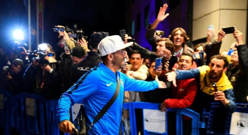 Carlos Tevez greets Boca Juniors supporters as his team arrive in Madrid for the delayed second leg of the Copa Libertadores final