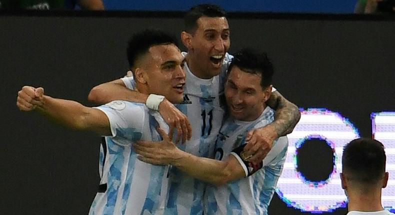 Lautaro Martinez (left) celebrates with his Argentina teammates Angel Di Maria (center) and Lionel Messi (right) after opening the scoring against Venezuela Creator: MAURO PIMENTEL