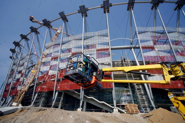 Ukończona bryła stadionu opleciona siatką w biało-czerwonych barwach robi imponujące wrażenie, podobnie jak wizyta na trybunach, gdzie robotnicy montują już krzesełka