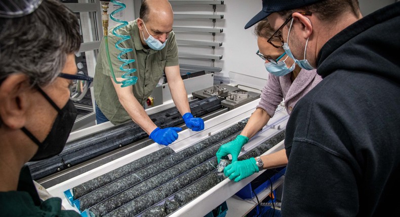 Researchers examining cores drilled from deep beneath the ocean.IODP JRSO