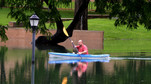 A kayaker rows through the flood waters above Sewell Park on the Texas State University campus near the headwaters of the San Marcos River in San Marcos Texas