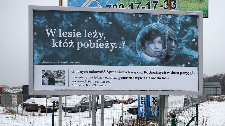 ‘’W lesie leży, któż pobieży…’’. Billboard na Dajtkach informuje o trudnej sytuacji migrantów na granicy z Białorusią