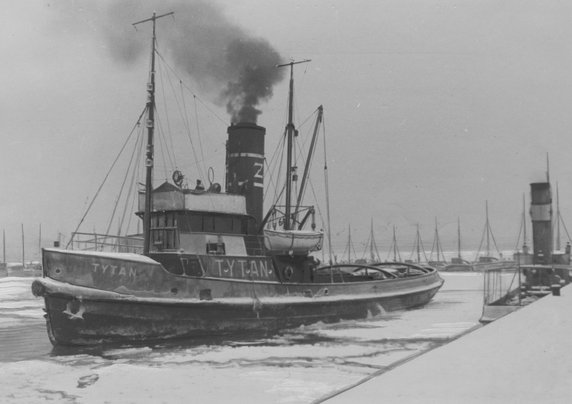 "Tytan" łamiący lód w jednym z basenów portowych w Gdyni. Przed wojną "Tytan" był największym i najsilniejszym polskim holownikiem. Wszedł do służby w 1936 r. Podczas wojny zarekwirowany przez Niemców, pływał pod nazwą „Zoppot”. Zatopiony w 1945 r. w porcie gdyńskim, po wydobyciu wyremontowany w Stoczni Gdyńskiej był nadal eksploatowany. Złomowany prawdopodobnie w 1980 r.