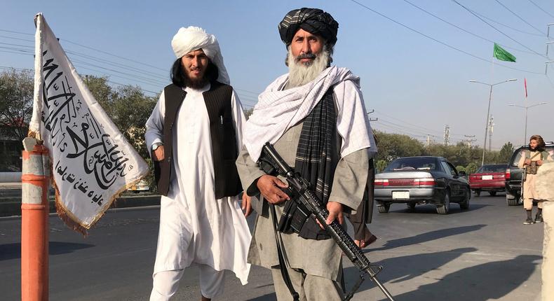 Taliban fighters stand outside the Interior Ministry in the Afghanistan capital of Kabul on August 15, after the militant force encircled and took over the city.
