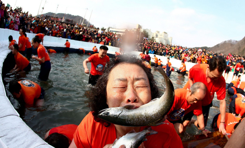 Uczestnicy corocznego święta Hwacheon Sancheoneo Ice Festival łowią ryby na zamarzniętej rzece w prowincji Gangwon w Korei Południowej