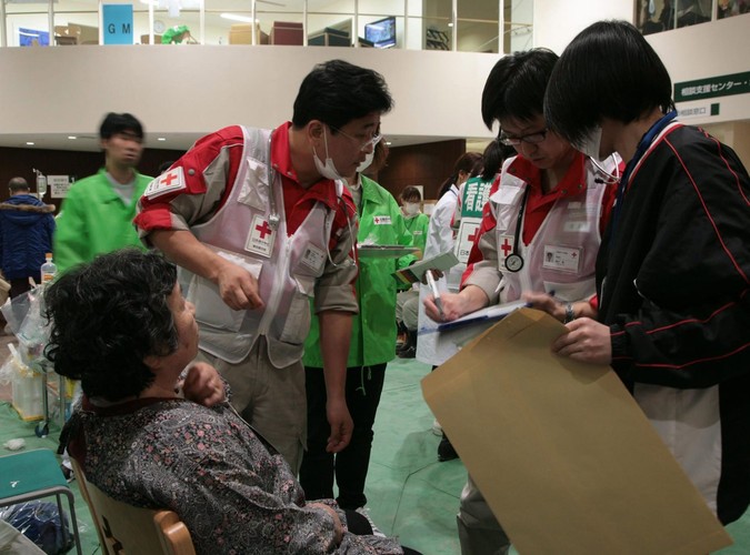 Pracownicy Czerwonego Krzyża udzielają pomocy potrzebującym w szpitalu w Ishinomaki w prefekturze Miyagi