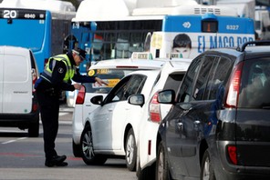 A police traffic officer speaks to motorists entering the center of Madrid