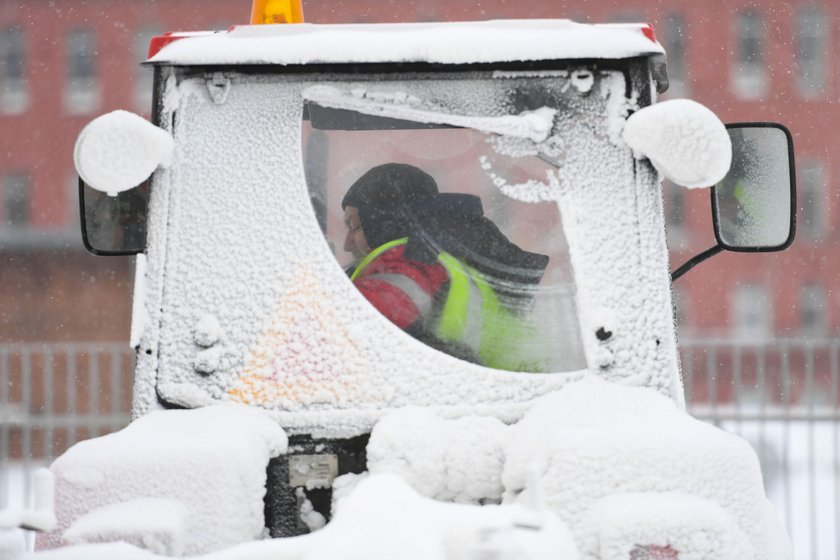 Workers remove snow in a street in Moscow