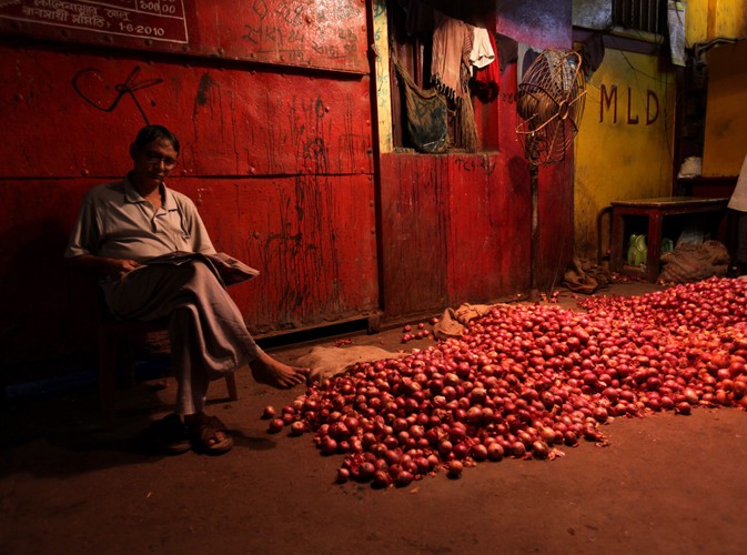 Wieczór w Kalkucie. Tapar Sarkar relaksuje się lekturą gazety, a towar czeka na ziemi na kupców