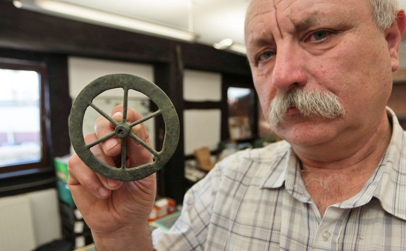 Stanisław Sinkowski z Muzeum Lubuskiego im. Jana Dekerta w Gorzowie Wielkopolskim prezentuje koło z wózka rytualnego