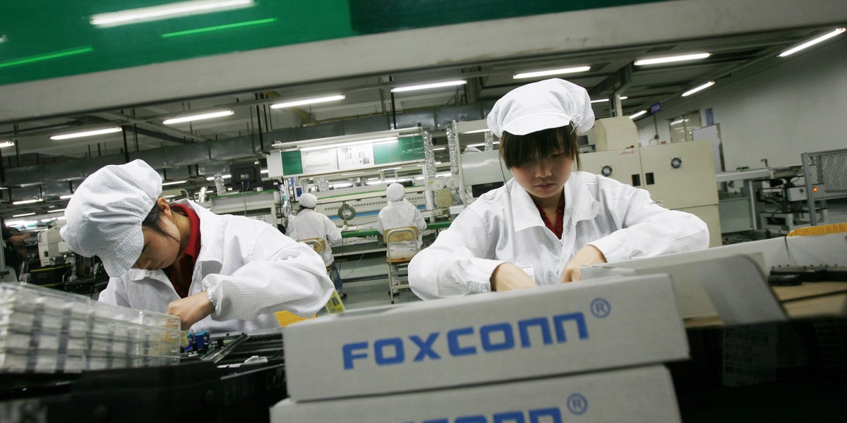 Pracownicy montujący telefony w zakładach Foxconn