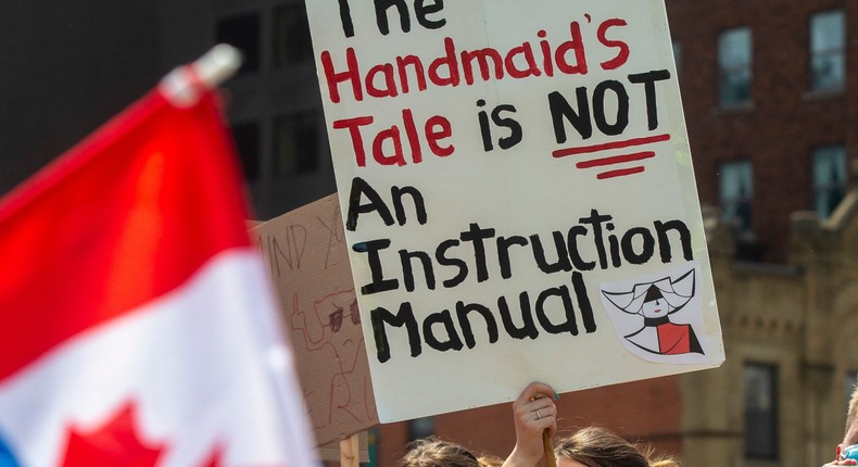 A pro-choice counter-protester holds a sign on the sidelines of the pro-life National March for Life in Ottawa, Ontario, on May 12, 2022.