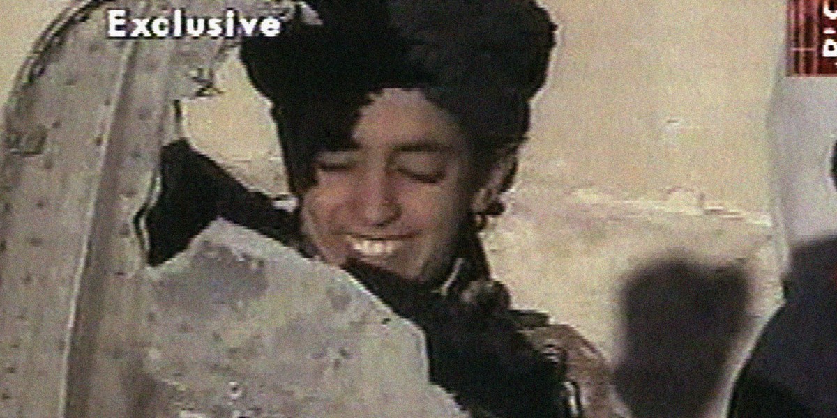 In this image made from video broadcast by Al Jazeera, a young boy, identified as Hamza bin Laden, holds a piece of US helicopter wreckage in Ghazni, Afghanistan, on November 5, 2001.