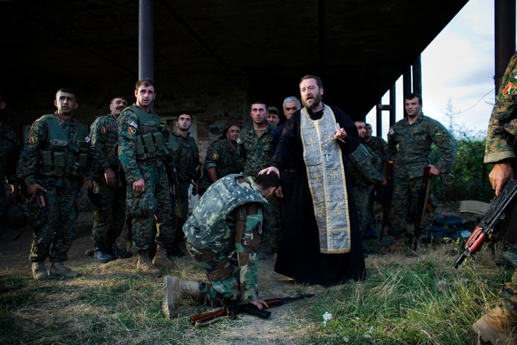 Duchowny udziela żołnierzom idącym na front komunii świętej i ostatniego namaszczenia
