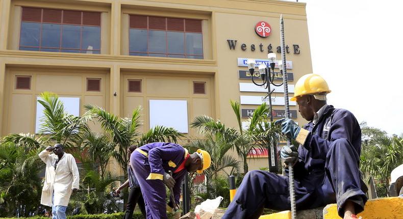 Construction workers dig holes to erect barriers at the reopened Westgate shopping mall, which was closed in the aftermath of an attack by militant gunmen in September 2013 that killed 67 people and injured many more, in capital Nairobi July 14, 2015. REUTERS/Noor Khamis