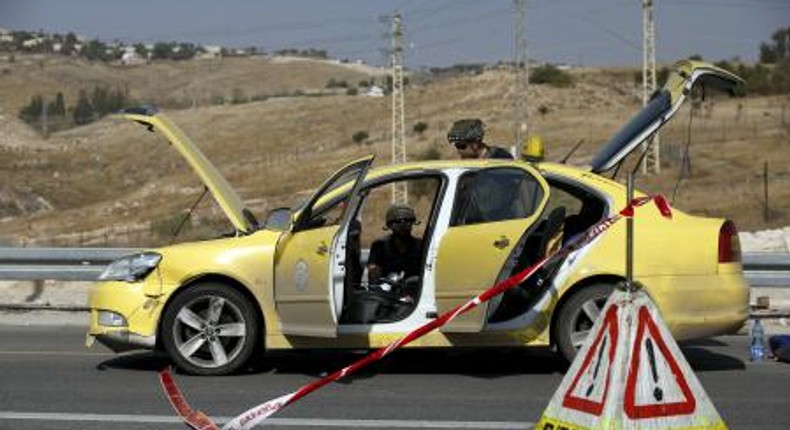 Israeli police explosives experts inspect a taxi at the scene of what police said was an attempted ramming attack near the West Bank Jewish settlement of Kfar Adumim November 22, 2015.